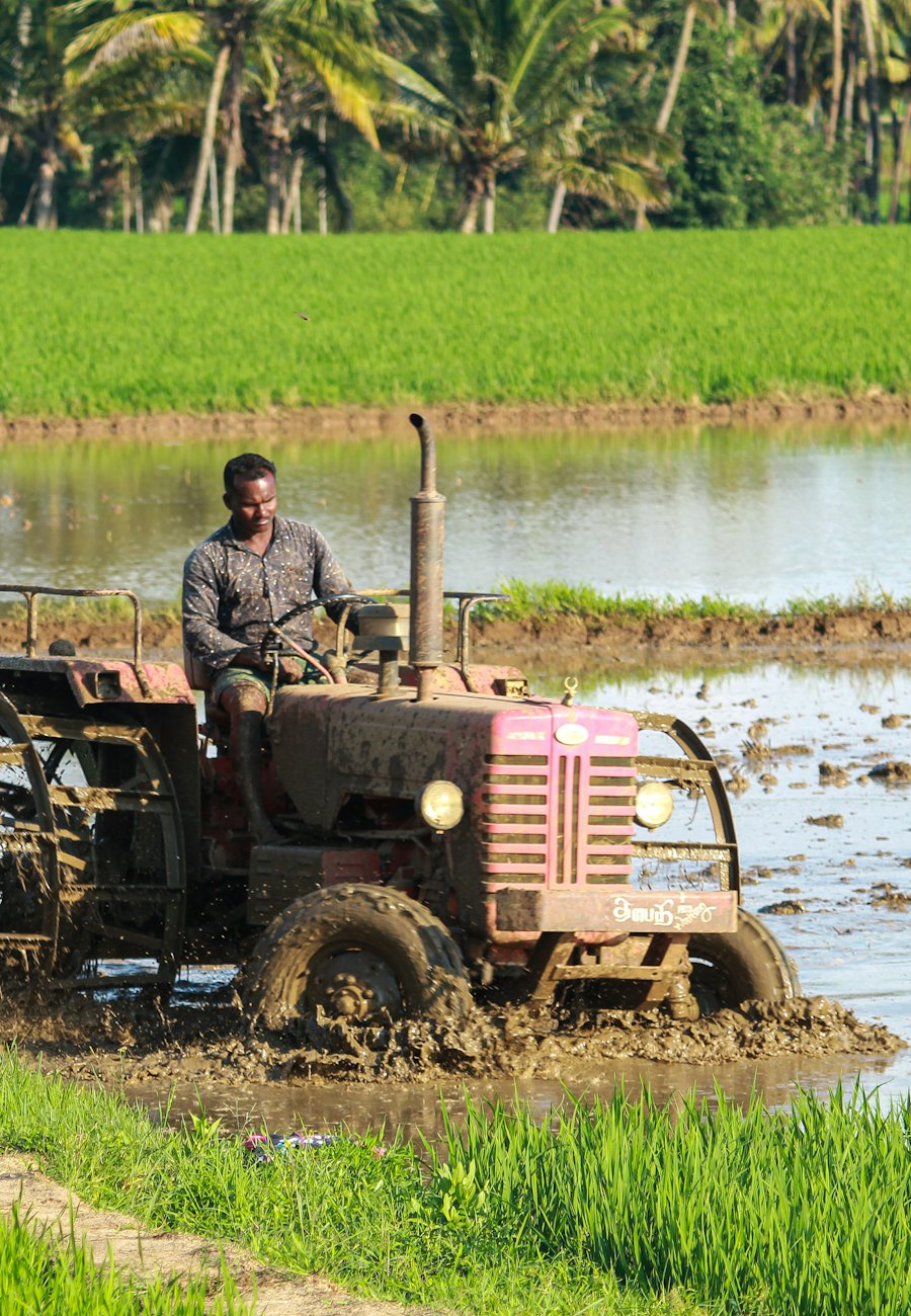 Farmer driving a tractor through a green field
